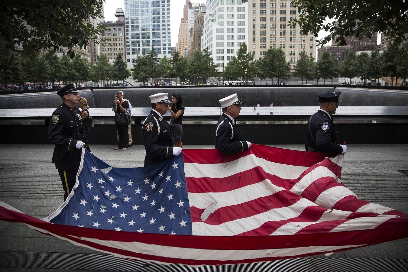 Miembros de la policía de Nueva York cargan una bandera estadounidense