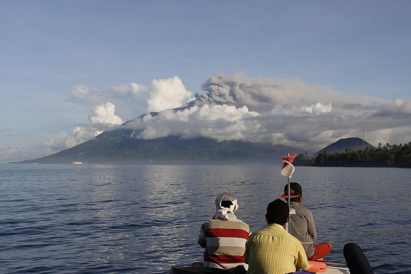Un grupo de pescadores indonesios observa la erupción del monte Gamalama, en el pico Ternate