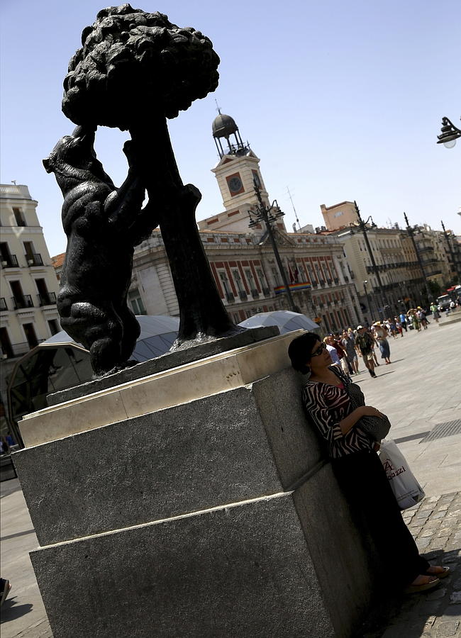 Una mujer a la sombra de la estatua del Oso y el Madroño en Madrid