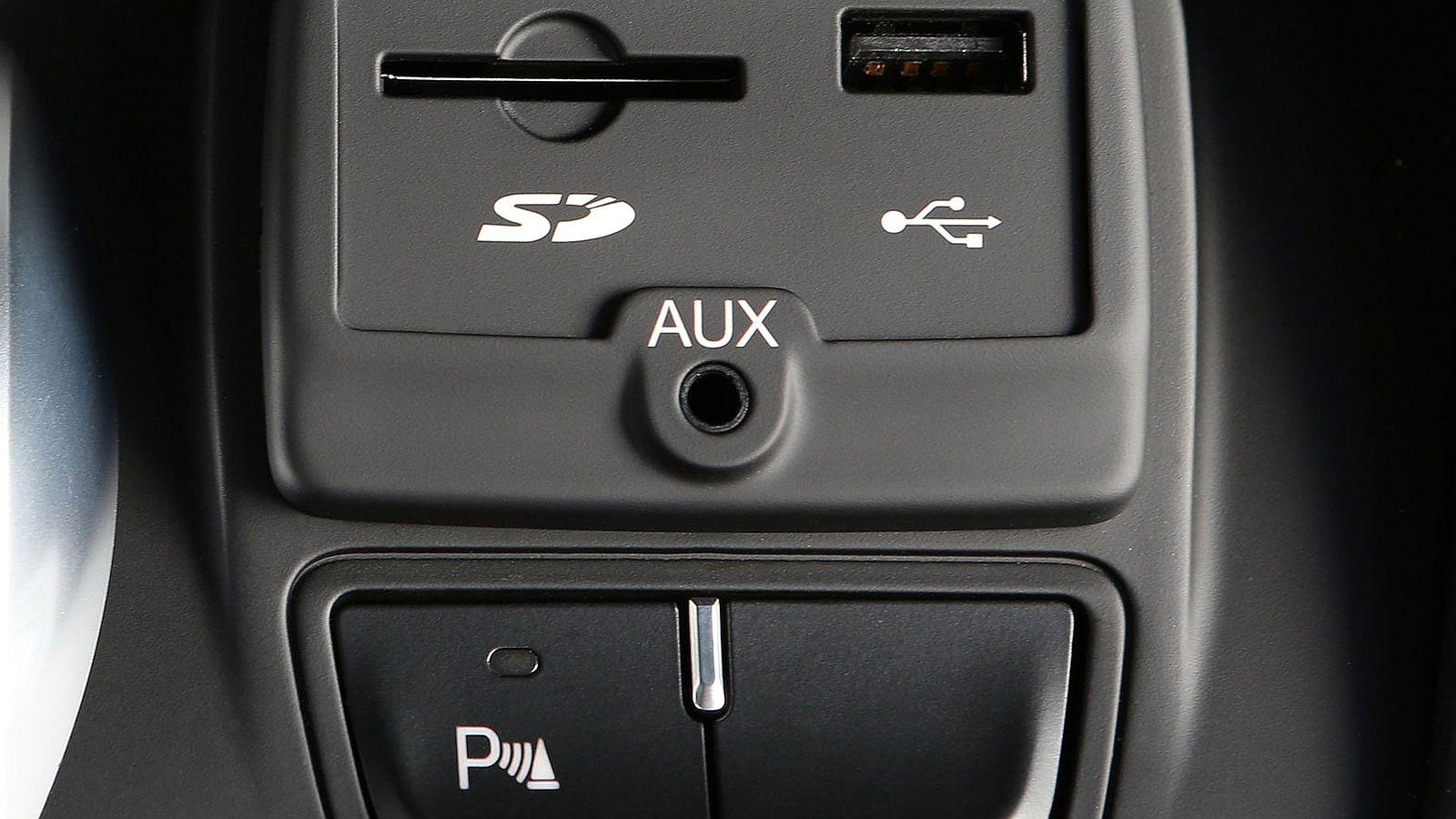Frente al selector del cambio hay una pequeña consola donde conectar desde una tarjeta SD a un iPod, o apagar los en ocasiones molestos sensores de aparcamiento
