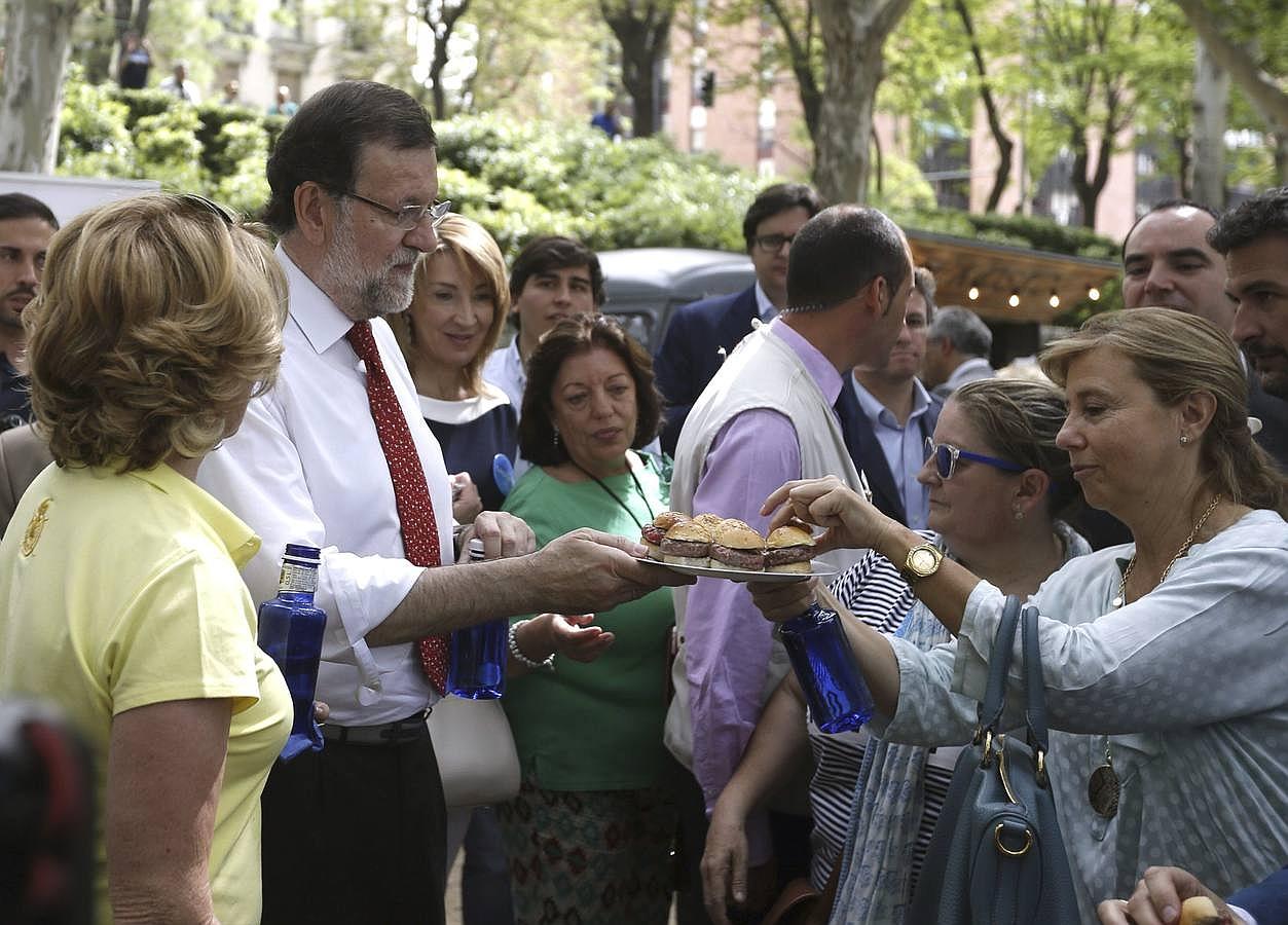 El presidente del PP y del Gobierno, Mariano Rajoy (2i), y la candidata a la alcaldía de Madrid, Esperanza Aguirre (i) repartían hamburguesas a varias simpatizantes tras dar un paseo en bicicleta por Madrid Río