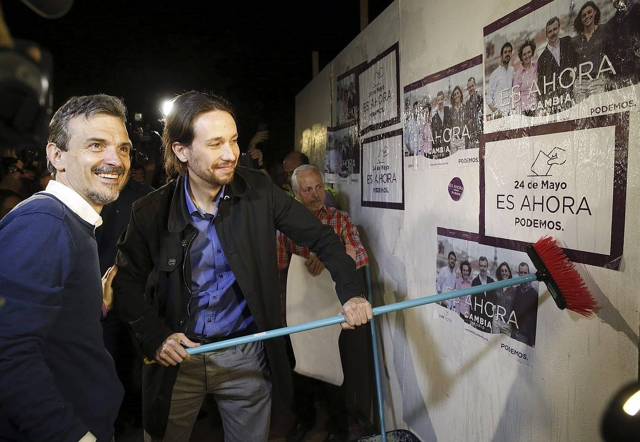 El secretario general de Podemos, Pablo Iglesias, y el candidato a la Presidencia de la Comunidad de Madrid, José Manuel López (i),durante la pegada de carteles celebrada en Madrid con la que iniciaban la campaña electoral
