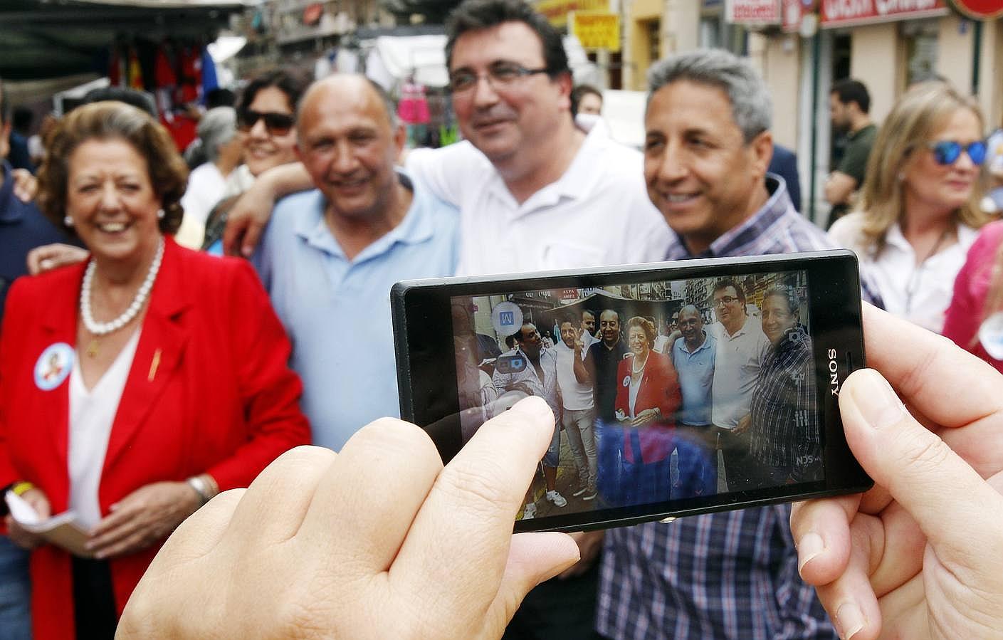 La alcaldesa de Valencia y candidata a la reelección, Rita Barberá (i), se hace una foto con unos vendedores durante su visita al mercado de Jerusalem