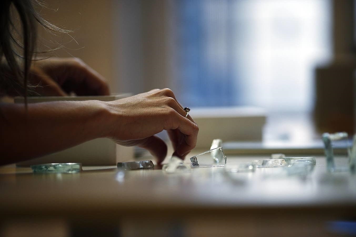 Llerena deposita algunos cristales sobre la mesa de trabajo del salón