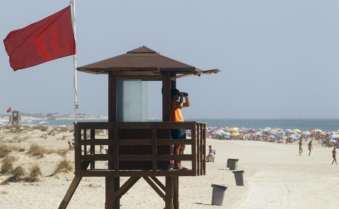 Un socorrista vigila atentamente la playa con bandera roja